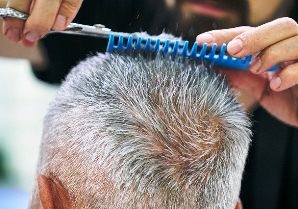 older customer getting hair trimmed by Hoover Alabama barber